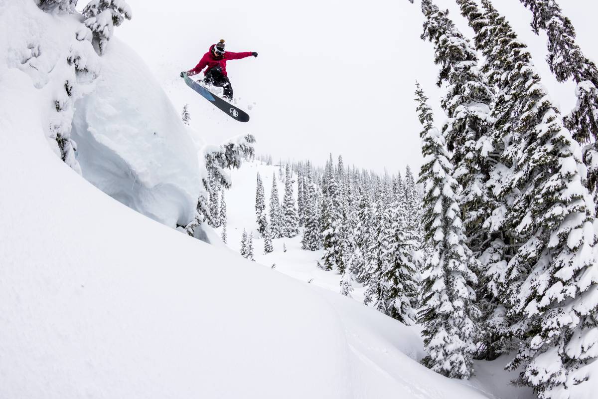 Photo by Ben Girardi of a snowboarder doing a jump of a steep hill.