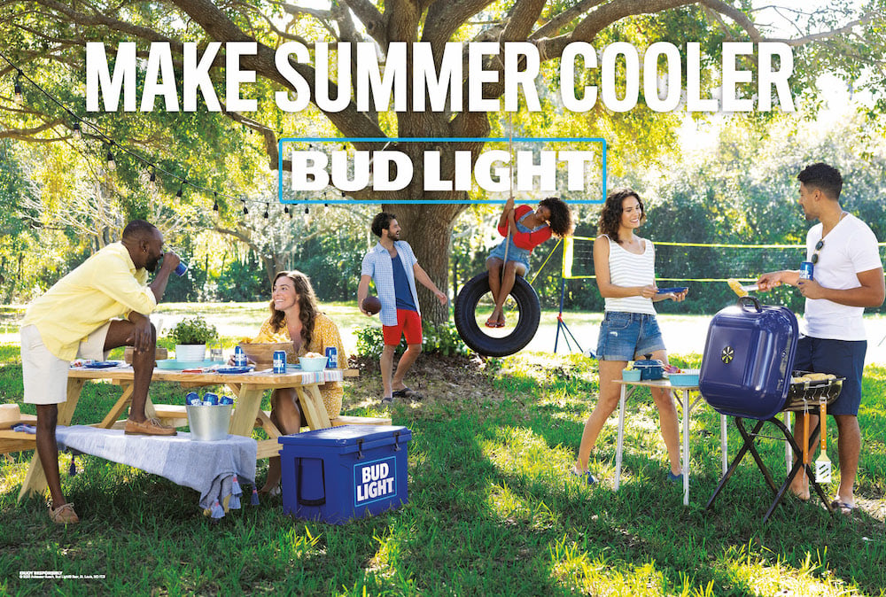 Photo with campaign name brand text of six friends at picnic in summer wear with Bud Light beers and tire swing, by Atlanta, Georgia-based brand narrative photographer Fernando Decillis.