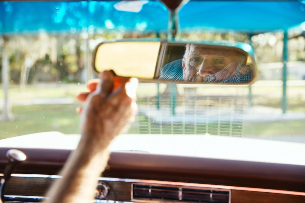 Portrait of man's face reflected in rear view mirror of classic car, by Altamonte Springs, Florida-based portrait photographer Brian Carlson.