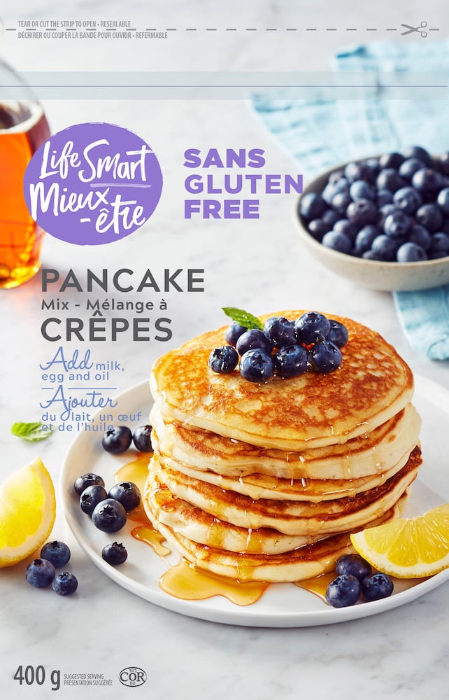 Photo ad for pancake mix, with tall stack of pancakes, maple syrup and blueberries, garnished with lemon wedges and mint, by Montreal, Canada-based food/drink photographer David De Stefano.