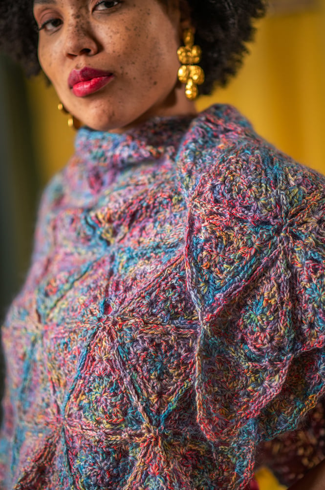 Closeup picture of colorful hand-knit, shawl wrapped around talent's shoulders, by Branford, Connecticut-based fashion photographer Gale Zucker. 