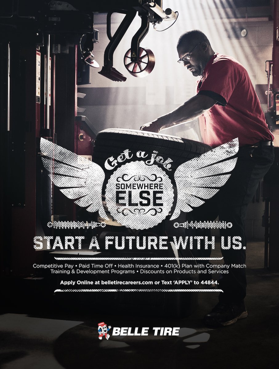 Tearsheet recruitment poster of Belle Tire employee in red uniform, lifting tire in mechanic's shop, by Chicago-based brand narrative photographer Nathanael Filbert.