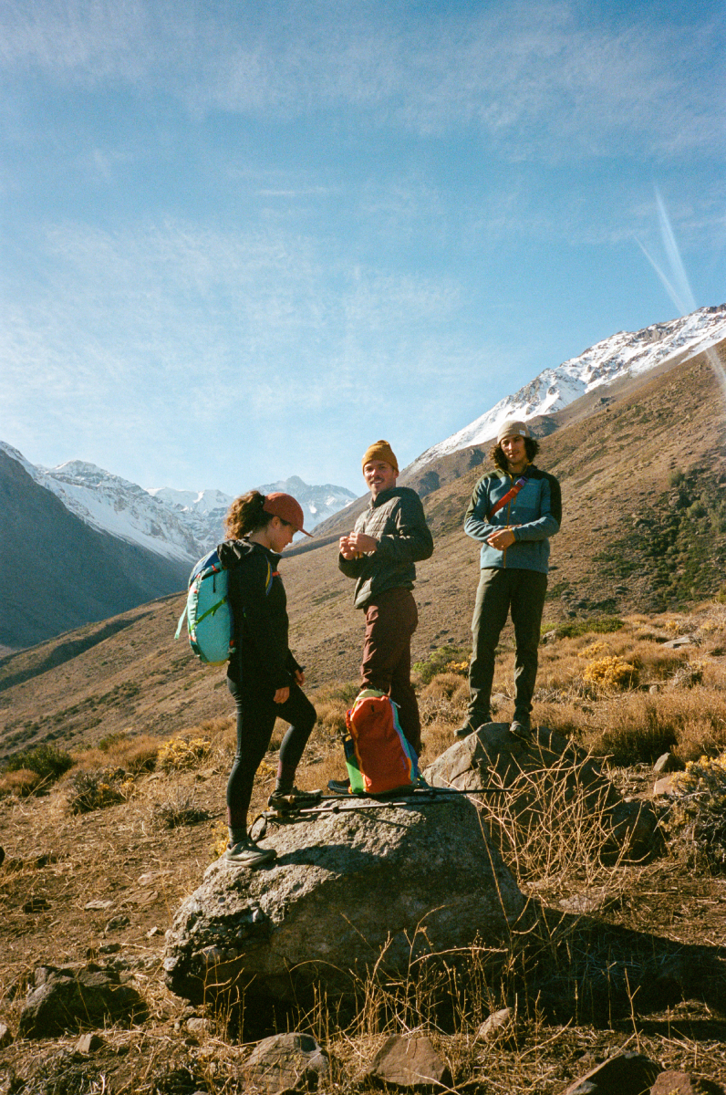 A color photo by Adam Wells of three models posing with Cotopaxi gear.