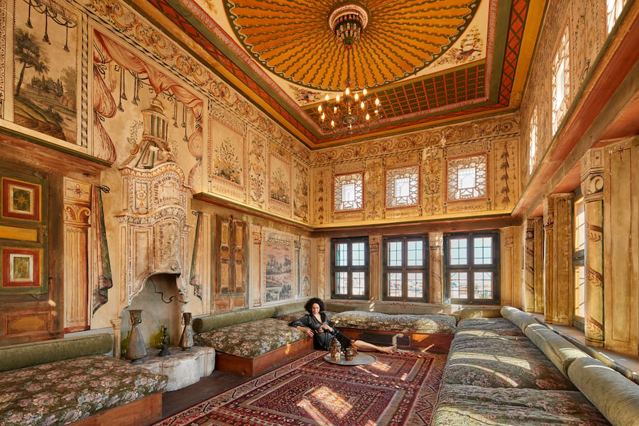 A woman lounges in an ornate, French style golden room by photographer Antonio Cuellar of Miami Florida. 