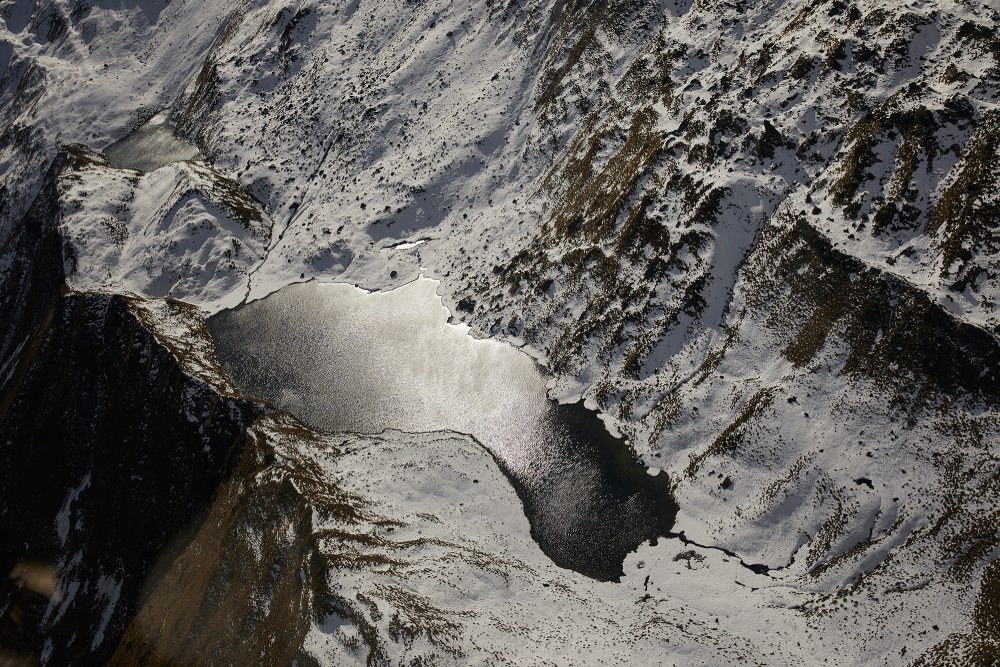 Photo by Chris Searl of a snowy mountain and river from above.