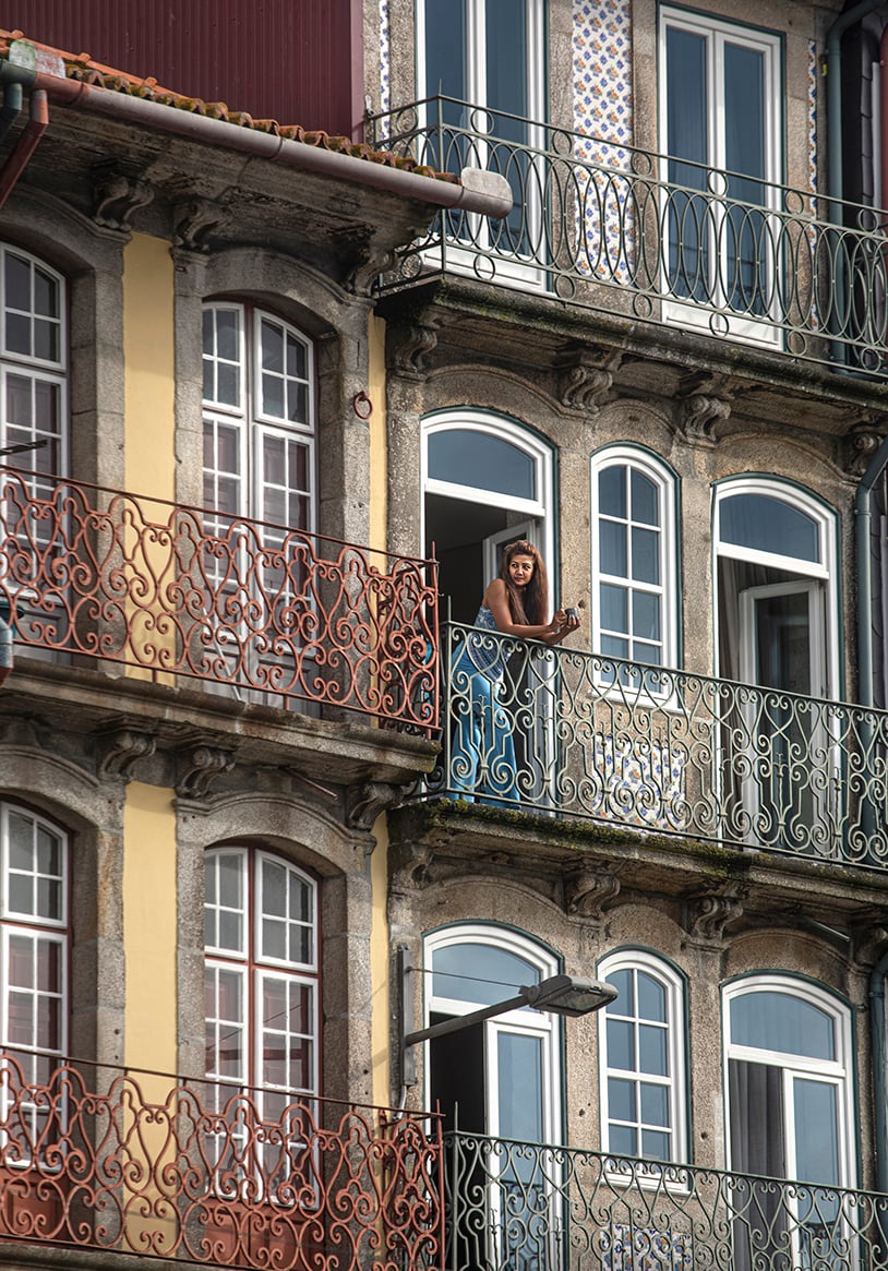 woman overlooking the city from her balcony, photo by Cristina Candel for El Mundo