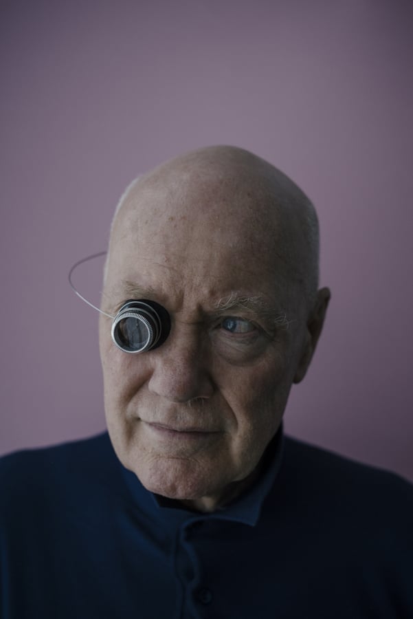 An elderly man looks through a single eye piece by Drik Bruniecki of Munich, Germany