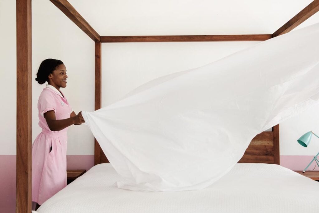 Photo by Emily Andrews of maid preparing bedding.