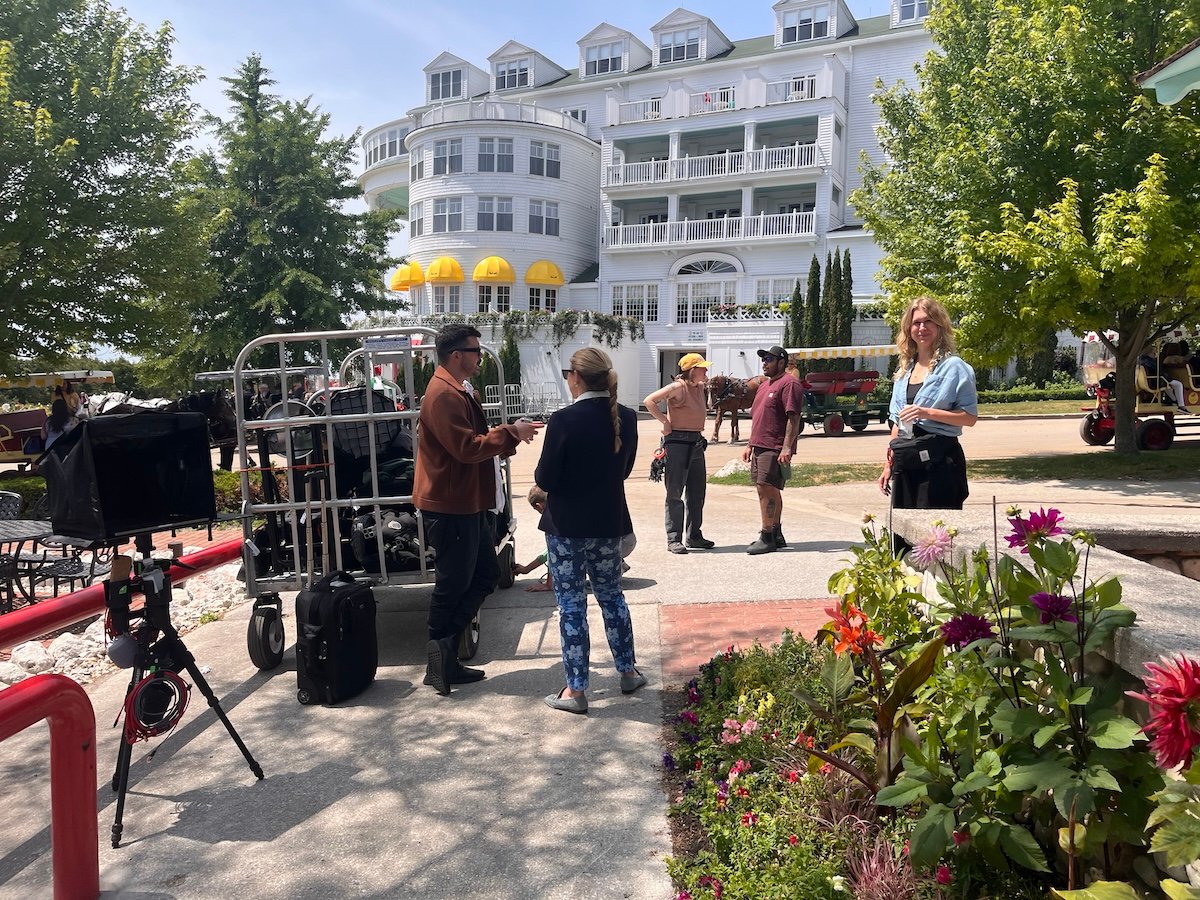 A BTS photo depicting the crew and photographer Lucy Hewett in front of the Grand Hotel.