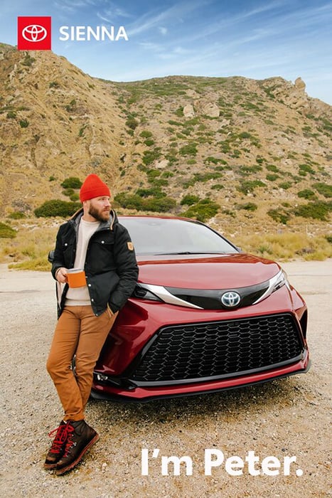 A portrait of a man leaning against a Toyota on a sunny day