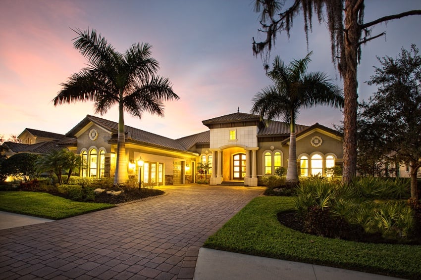 Ken Redding's photo for Neal Communities of one of their buildings. The photo is taken at twilight, and the sky is pink and blue. The property features immaculately manicured landscaping with tropical flora including a number of palm trees.