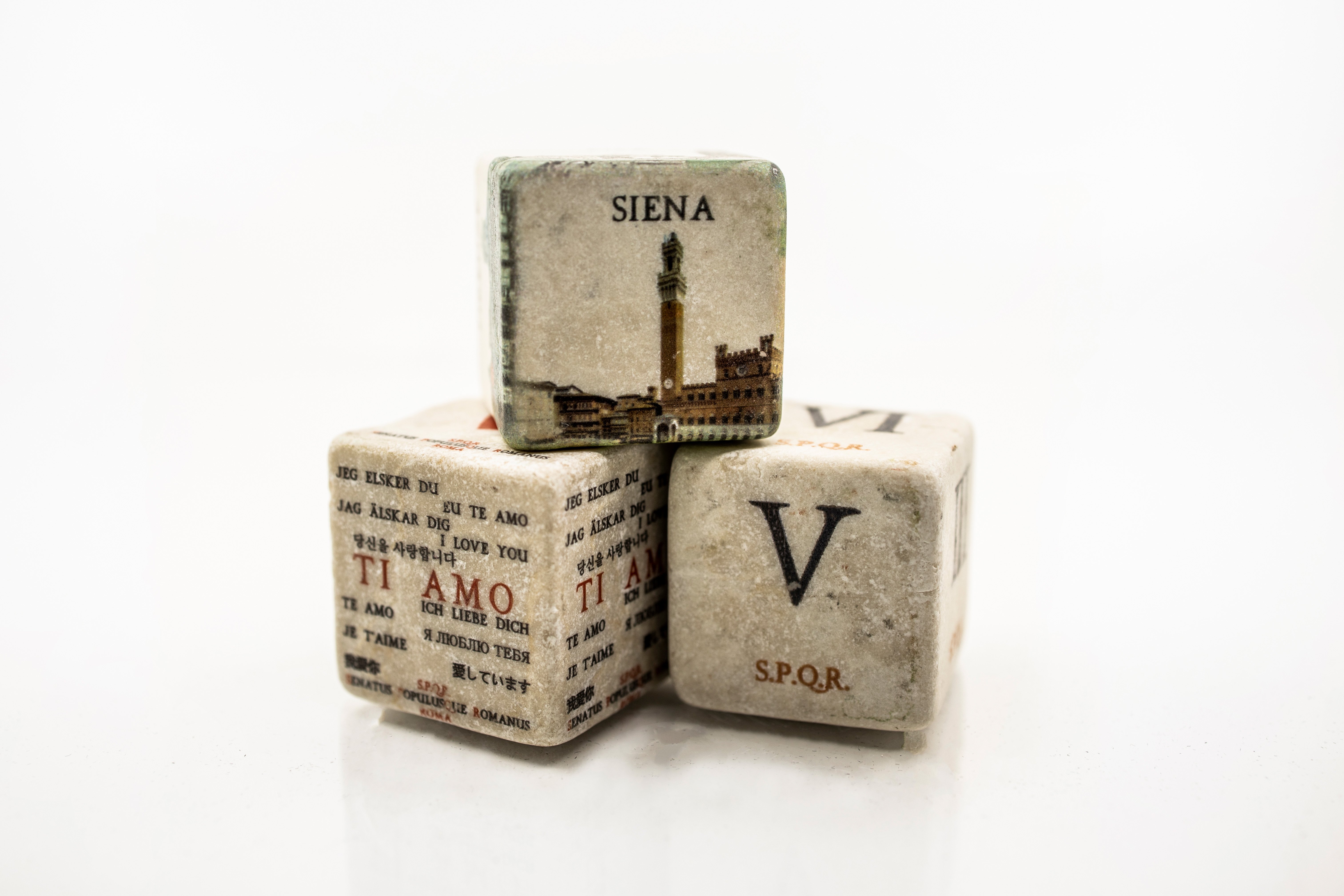 Shea Winter's personal shot of 3 very old dice. One has the Roman Numeral V, one says Siena, and one says Ti Amo