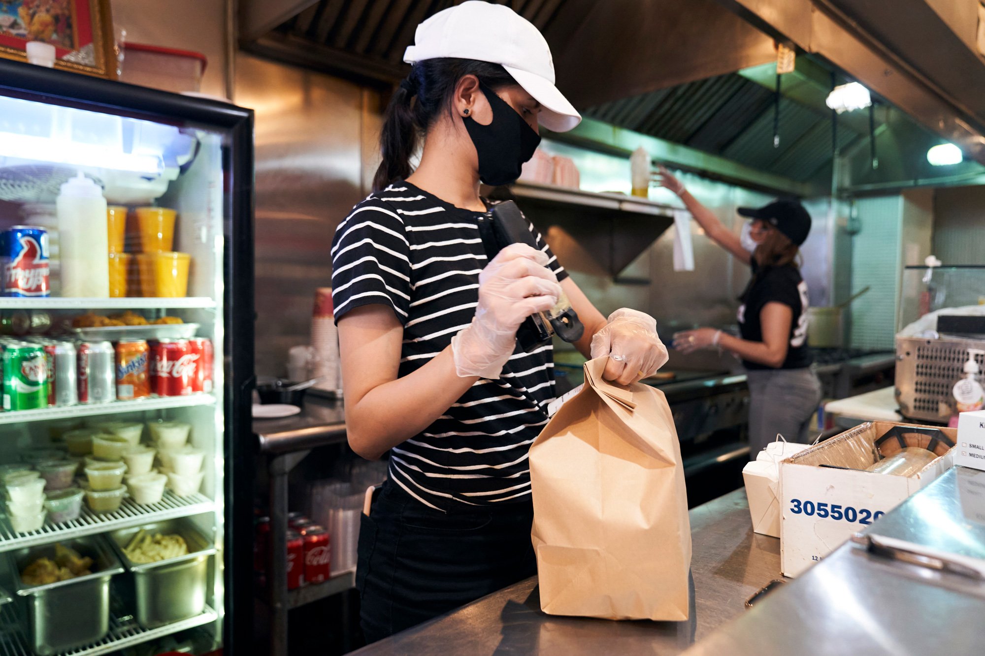 Woman working in a restaurant wearing PPE