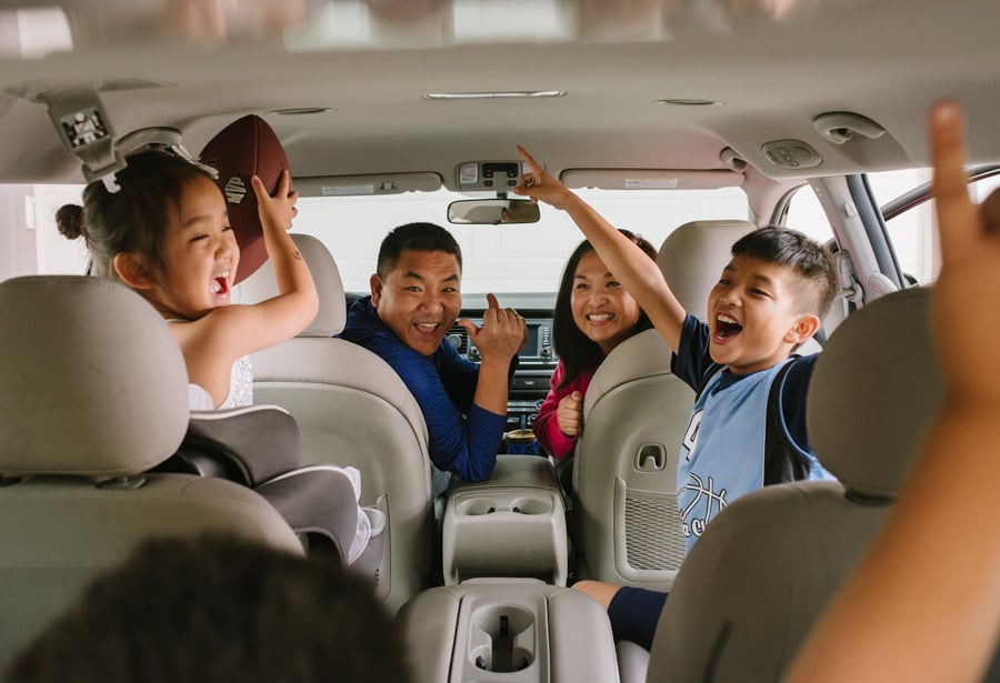 An excited family is cheering in the car, perhaps about to embark on a roadtrip, by photographer Tiffany Luong of Alhambra, California