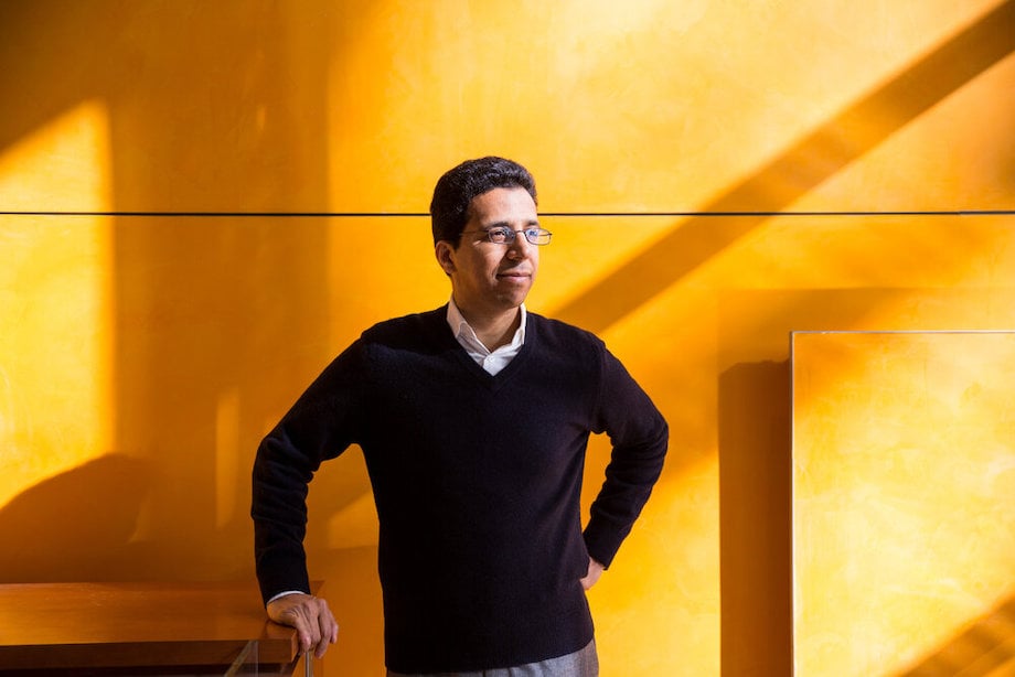 Portrait of figure standing before warm yellow wall,  by New York Corporate photographer Adam Lerner