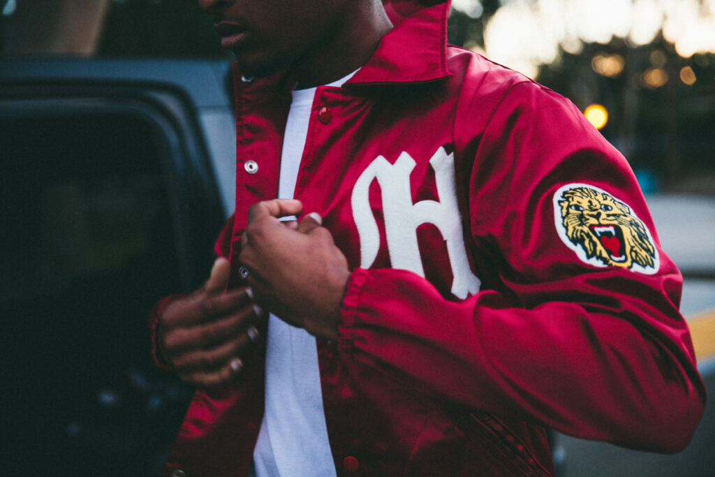 San Diego fashion photographer Alan Nakkash's photo of a cherry red letterman jacket on a male model. The jacket features a patch of a roaring lion on the left bicep. 