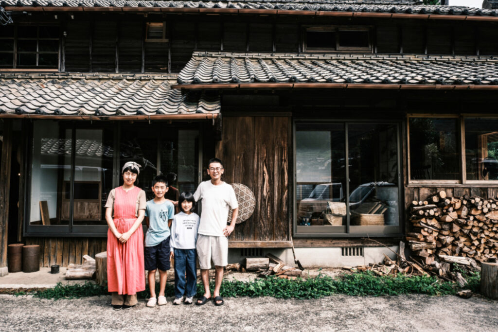 The Takuma family stands with pride in front of their home, photo by Ben Weller.