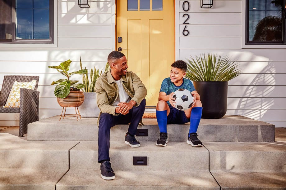Photo of a father and his son holding a football taken by Los Angeles-based lifestyle photographer Bethany Nauert.