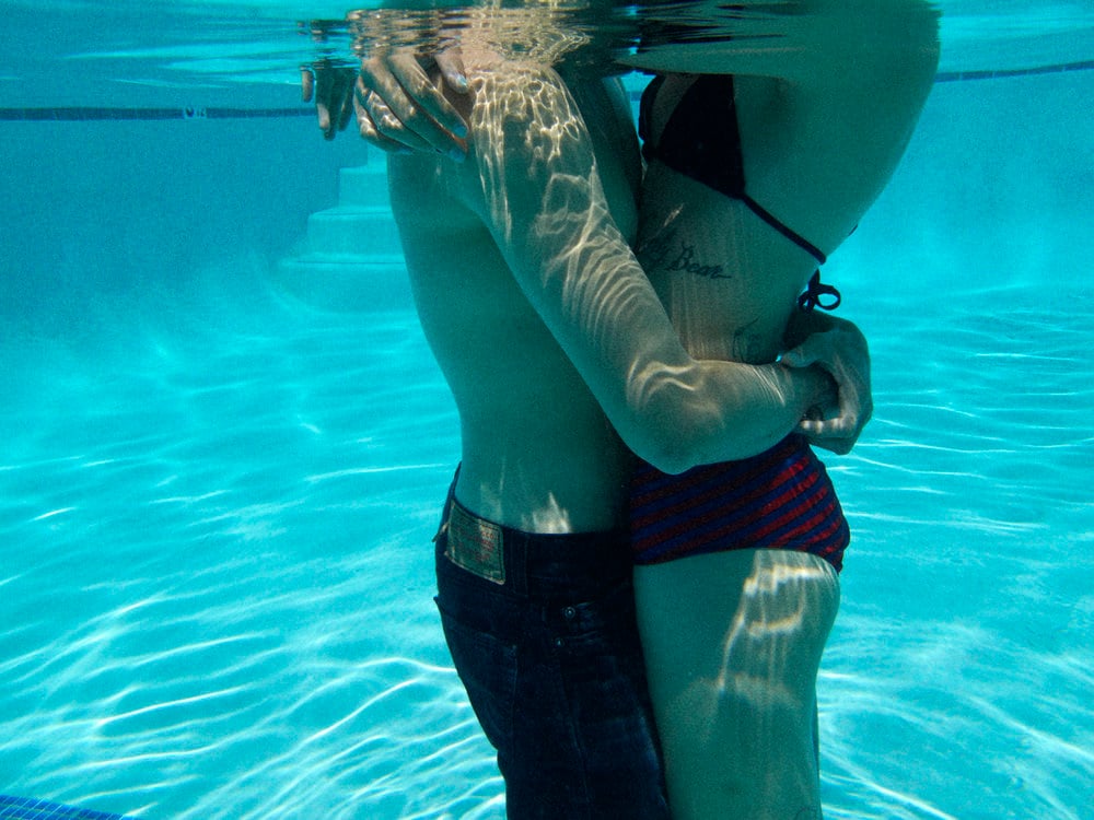 Photo by Chris Searl of a couple embracing one another beneath the water's surface.