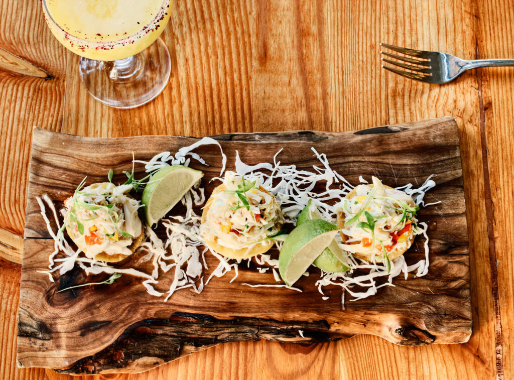 Photo by Craig Washburn of a wooden plate of high-end tacos.