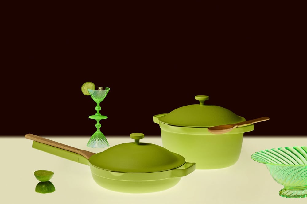 Photo by Cydney Cosette Holm of two green pots sitting before a black background with other green kitchen items.