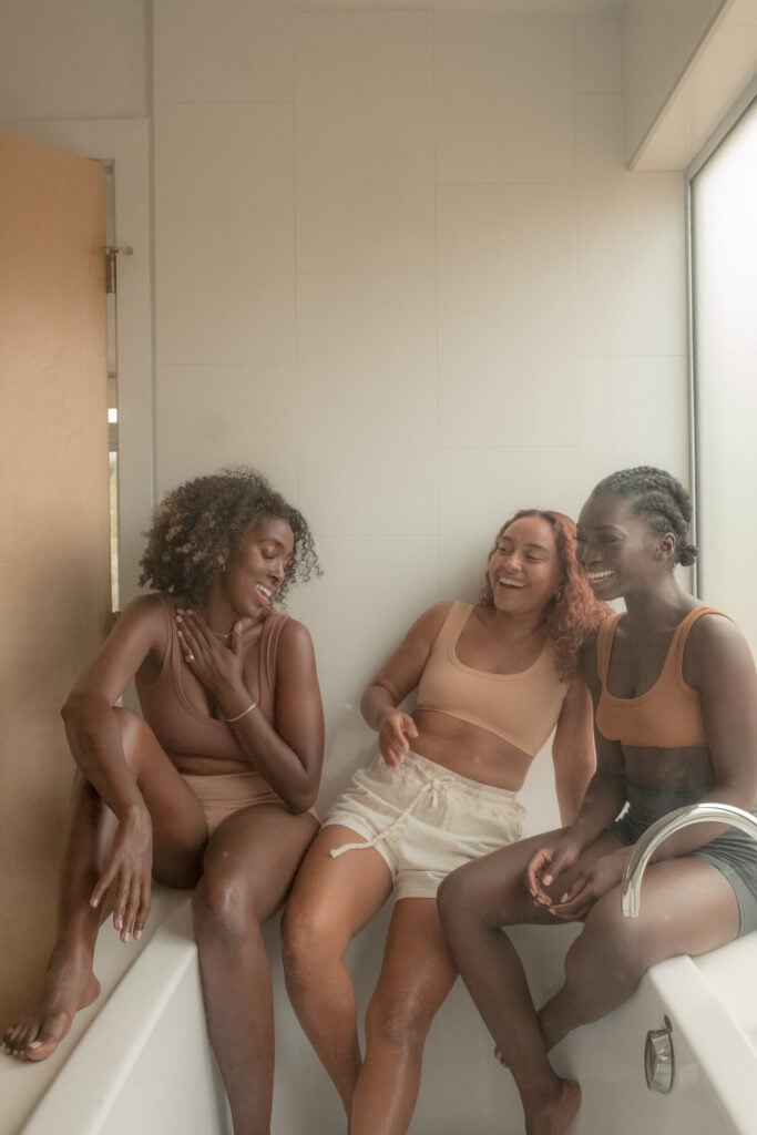 Photo by Deun Ivory of three girls laughing in a bathtub.
