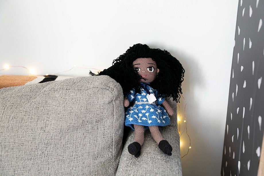 A still life image of a fan-made crotchet doll sitting on a sofa in the home office, taken by LA and New York-based photographer Emily Malan