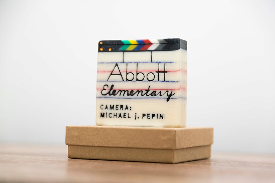 A still life portrait of a clapperboard sculpture with the show title "Abbott Elementary" engraved on it