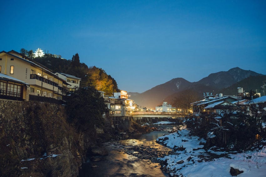 Gifu City draped in a serene blanket of snow, with the tranquil river winding through the heart of the winter landscape, photo by Irwin Wong.