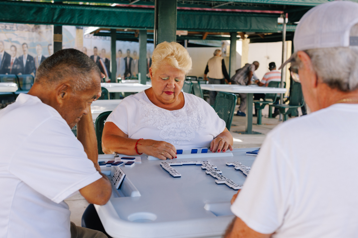 A color photo of Maria Verde and friends play dominos at Domino Park on Calle Ocho in Little Havana.