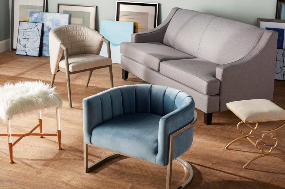 A color photo by Kortney Golska of an  arrangement of furniture - a couch, two arm chairs, and two stools - in the living room of a home.
