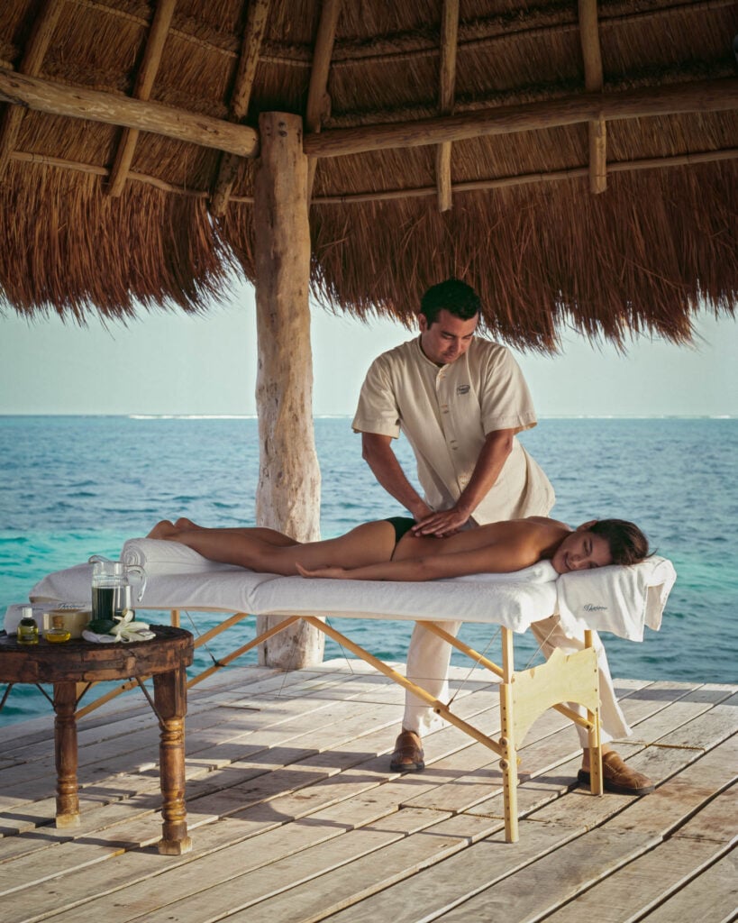 Photo by Michael Grimm of a woman getting a massage by the ocean.