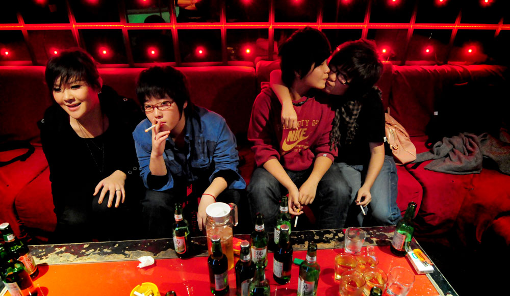 Photo by Mindy Tan of young people drinking and smoking at a nightclub.