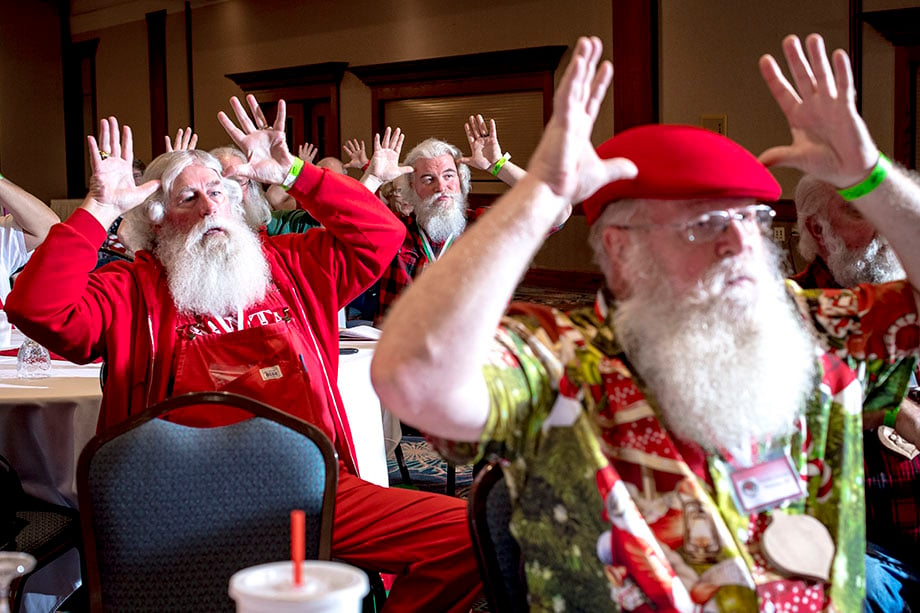 Carl Raysin of Grand Blanc, Mich., center, learns sign language with other Santas during the 84th annual Charles W. Howard Santa Claus School 