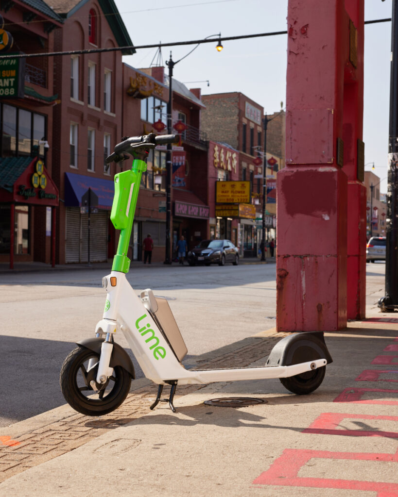 An image of Lime's sleek electric scooter elegantly stationed amidst the vibrant urban landscape of Chicago's bustling streets, photo by RIcky Klüge.