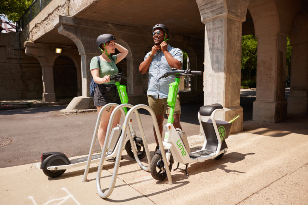 A man and a woman stand ready to embark on a thrilling ride aboard Lime's electric scooters.