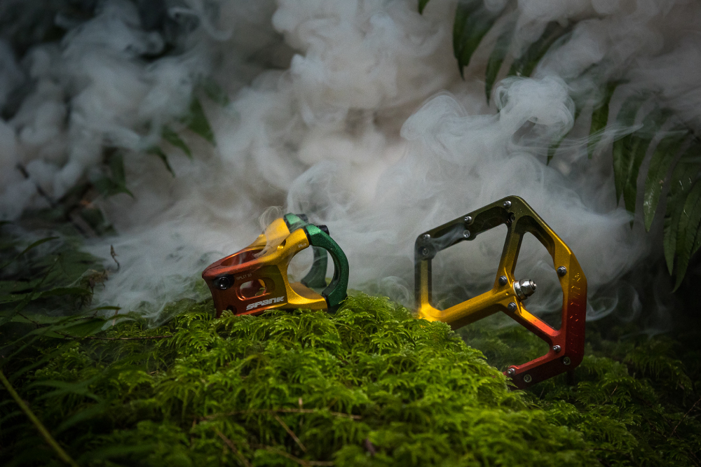A color photo by Riley Seebeck of bike pedals placed in a mossy and smokey environment. 