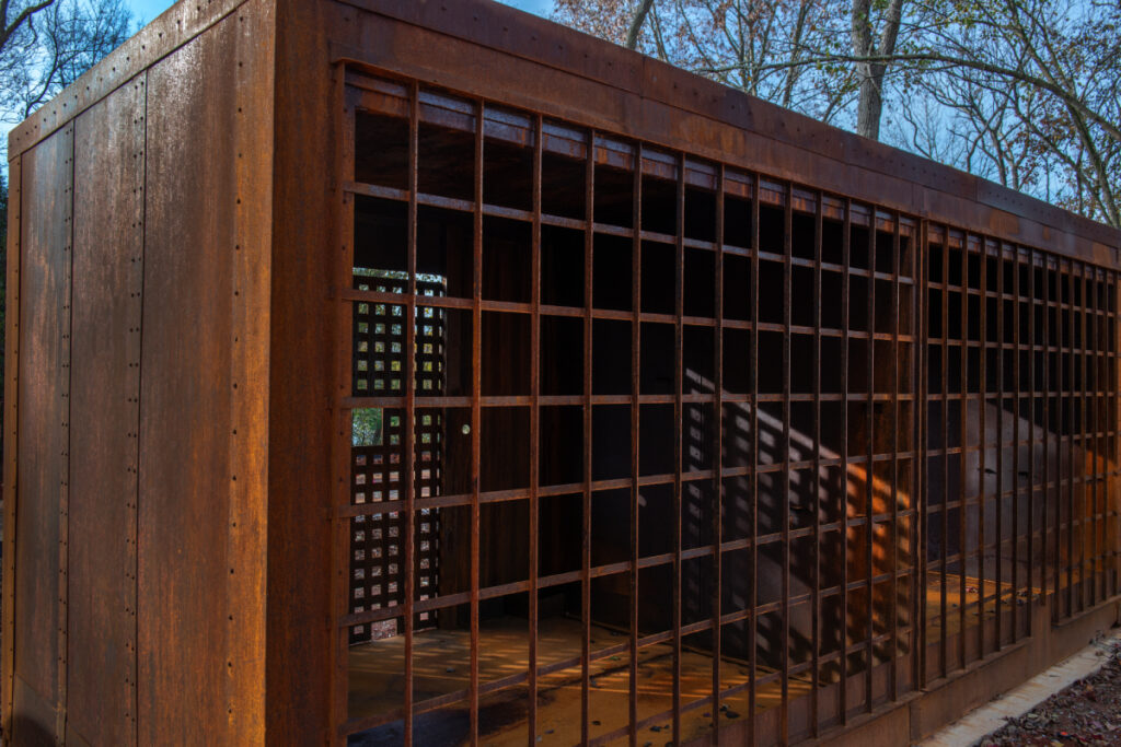 Image showing a metal cage, once used to confine slaves, now stands as a powerful reminder of a dark chapter in history, photo by Robert Rausch.