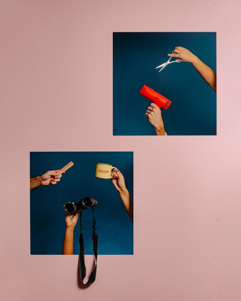 Photographer Samuel Greenhill's photo featuring an array of objects for styling hair (scissors, pink comb, red hairdryer) in addition to a pair of binoculars and a mug. Each object is held up by a hand. The owners of the hands are not in frame. 