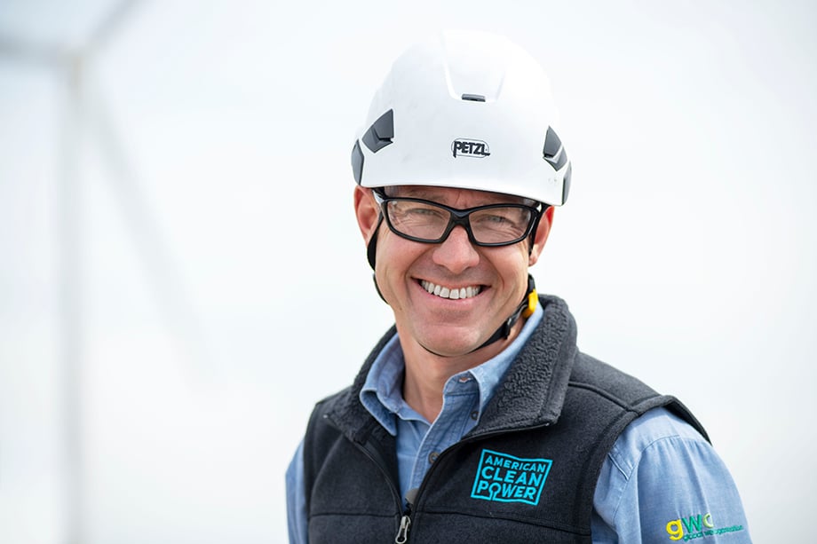 A worker wearing a helmet and vest, which reads "American Clean Power." Portrait taken by industrial photographer Sean F. Boggs