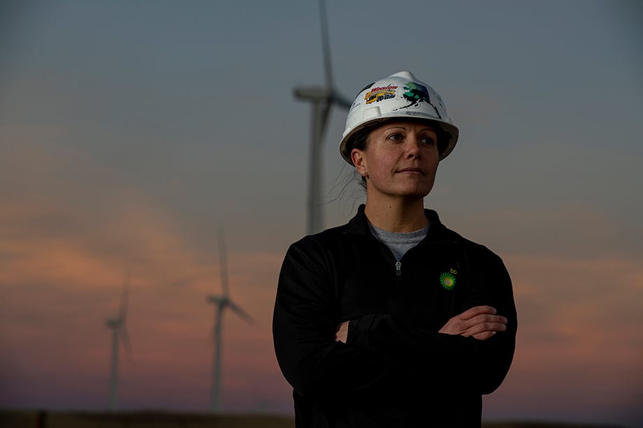A wind farm worker stands in front of the sunset with the windmills in the distance, shot by Eagle, Colorado-based photographer Sean F Boggs