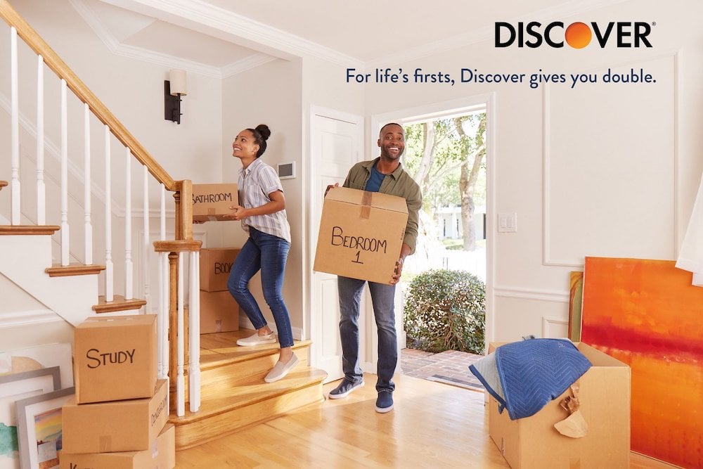 Tear sheet of two figures carrying labeled moving boxes into new home, smiling in the entryway, by Miami-based Corporate and Portrait Photographer Steve Boxall.