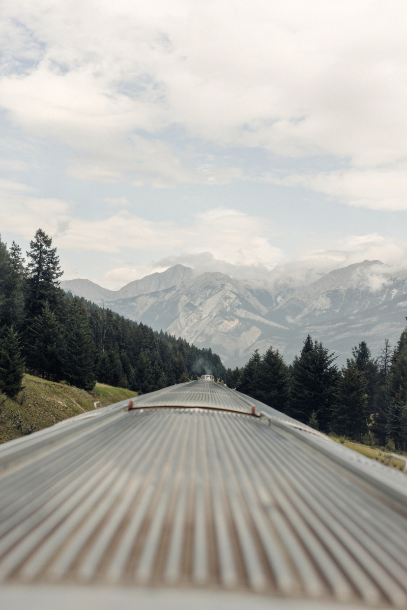 A color photo by Taylor Roades of the outer roof of a train looking towards a mountainous horizon.