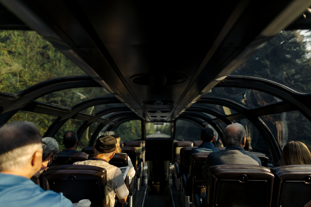 A color photo by Taylor Roades of a glass ceiling train car with passengers.