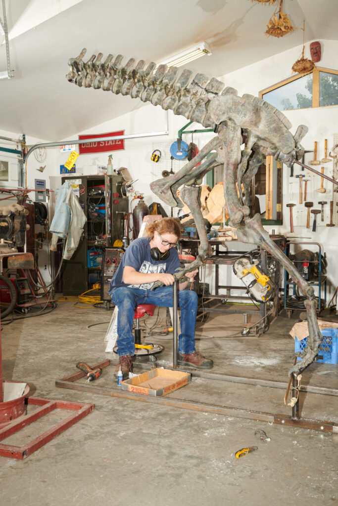 One of the workers assembles a Ceratosaurus model at Gaston Design, photo by Theo Stroomer.