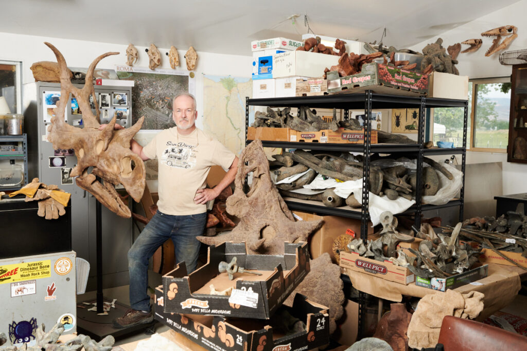 The owner of Gaston Designs, Rober Gaston poses next to a replica of Diabloceratops in his warehouse, photo by Theo Stroomer.