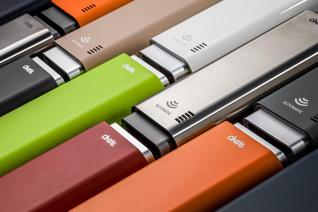 An image by Cincinnati-based product photographer TJ Vissing of a closeup of an arrangement of a Cintas product in several colors (lime green, scarlet, orange, black, chrome, white, taupe). The objects are arranged like a masonry wall.