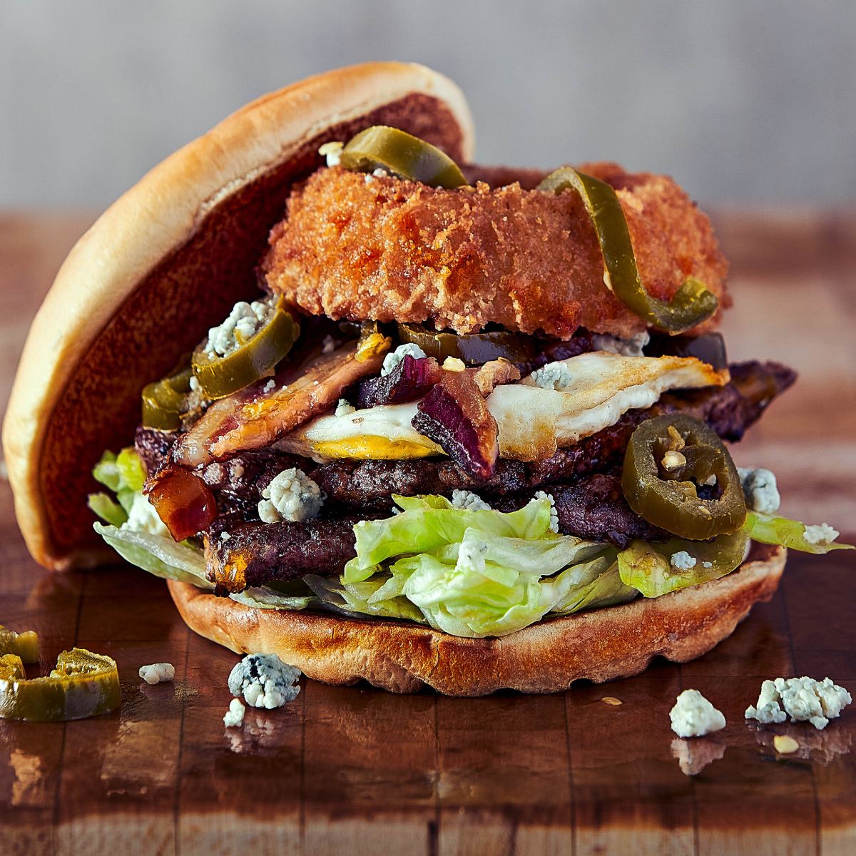 A color photo by Vanessa and Seth Weber of a hamburger piled with toppings. 