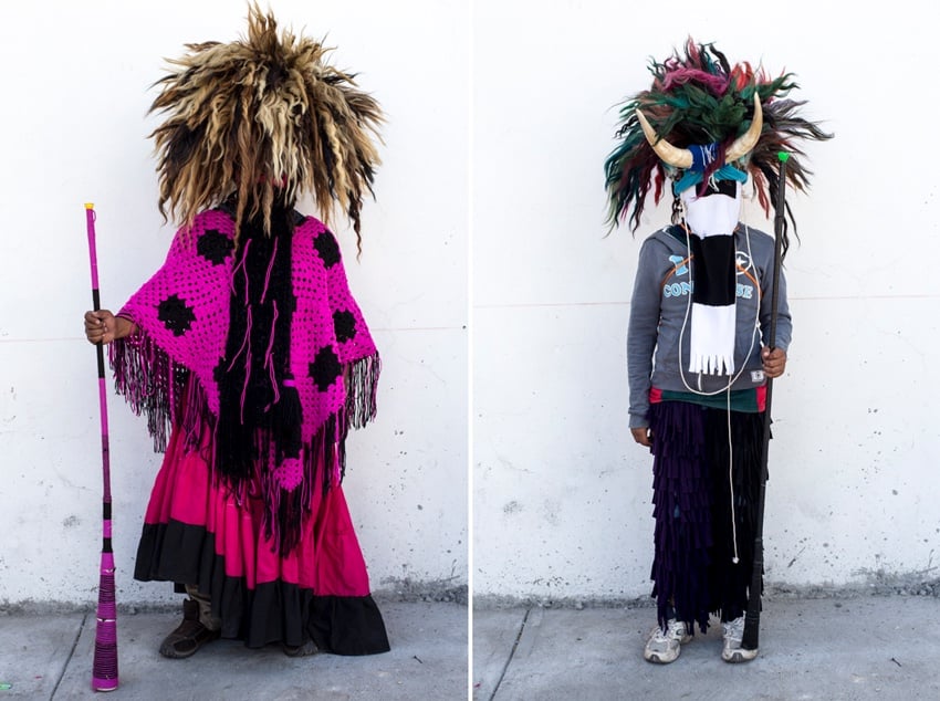 A diptych of photos by Walter Shintani. Each photo features an individual dressed for the Fiesta Xhita. On the left, a person wears a headdress that looks like a voluminous blonde and brown wig and hot pink clothes. The person on the right wears a similar wig but multicolored. This person also has a horn affixed at their forehead and their face is covered with a cloth.