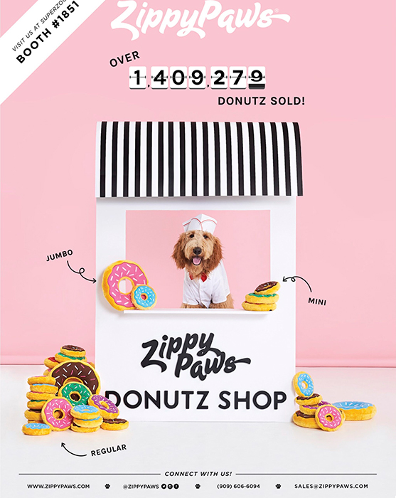 A portrait of a dog against a pink background, surrounded by stuffed "Donutz" toys for Zippy Paws